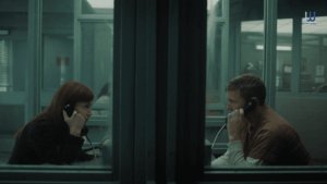 I Will Find You - Rachel and David speak through a prison glass partition in a tense scene from the Netflix series